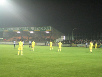Im Hintergrund die einzige Sitzplatztribne im Stadion Marcel de Kerpel